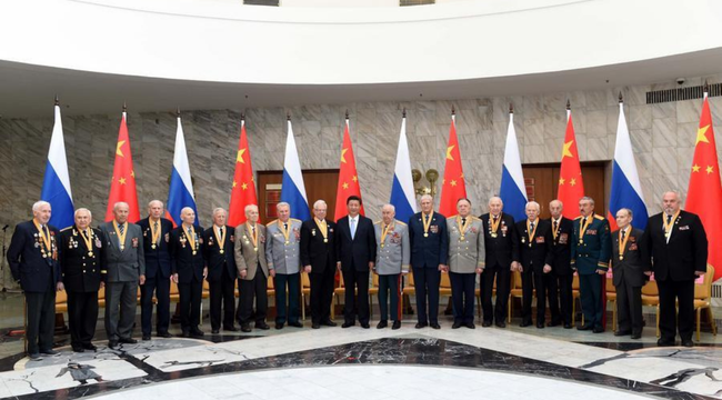 Xi Jinping posa junto a veteranos rusos frente a las banderas de China y Rusia