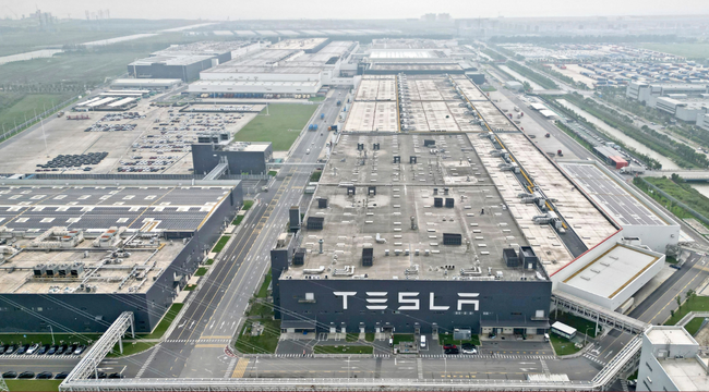 Vista aérea de un complejo industrial de Tesla con edificios de producción y estacionamientos.